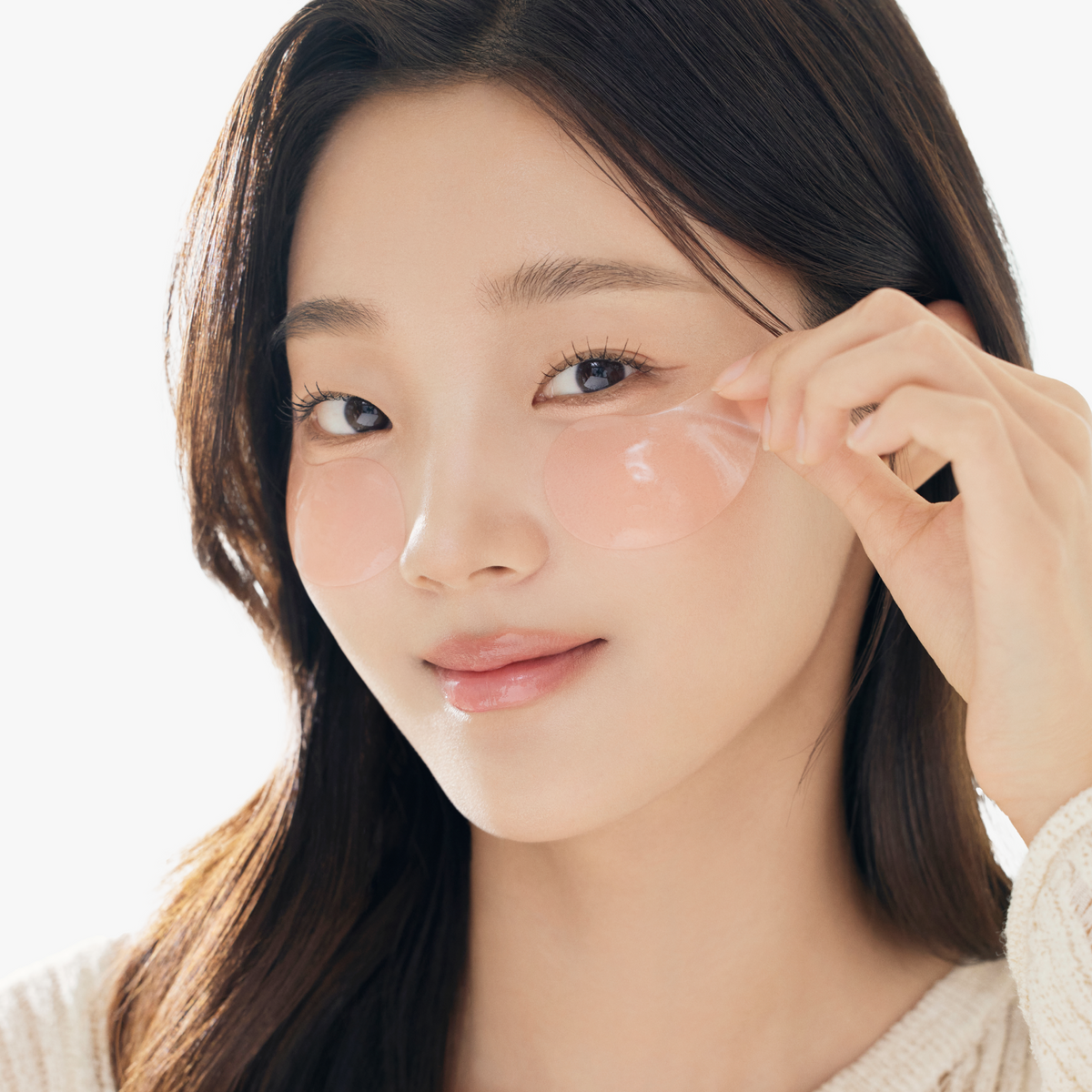 Model gently applying COSRX The Peptide Collagen Hydrogel Eye Patch to under-eye area, showing smooth pink hydrogel texture; enriched with peptides, adenosine, and niacinamide to improve dark circles, puffiness, and firmness for a radiant, revitalized look.